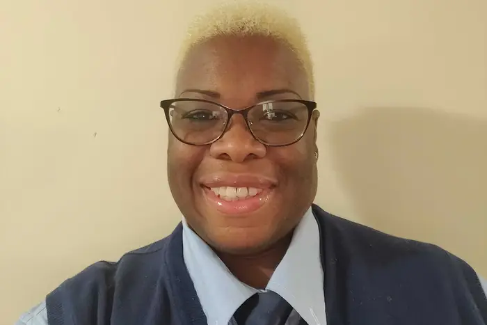 Photograph of Neosha Williams, who is smiling and has glasses on and her hair is blond and  cut short